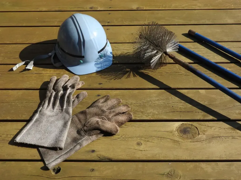 Équipement professionnel de ramonage (casque, gants et hérisson) dans le Calvados